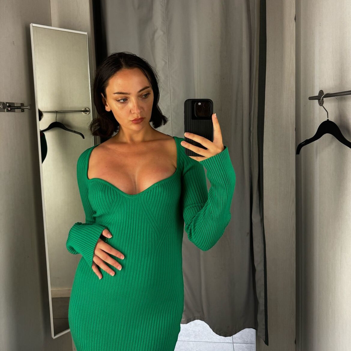 Lea Voisin prøver en grøn kjole på i et prøverum efter sin brystforstørrende operation